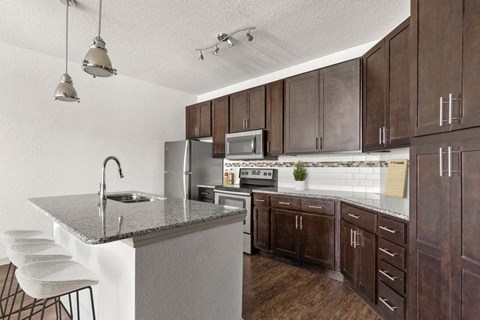 a kitchen with wooden cabinets and a granite counter top