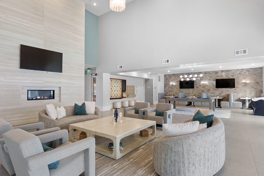 A modern living room with a fireplace and a flat screen TV mounted on the wall.