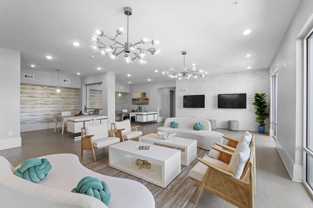 A modern living room with white furniture and a chandelier.