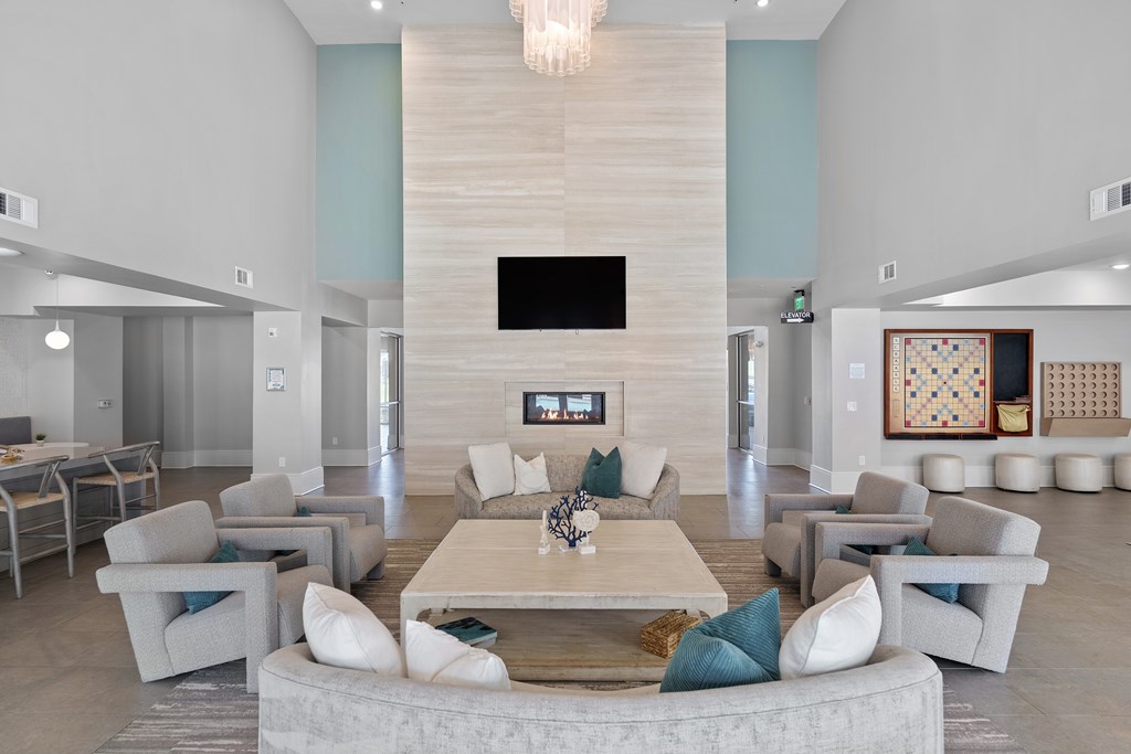 A modern living room with a large grey sofa set and a fireplace.