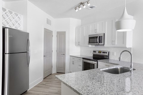 a kitchen with granite counter tops and stainless steel appliances