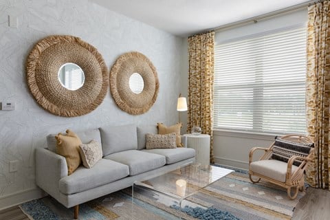 a living room with a couch and two mirrors on the wall