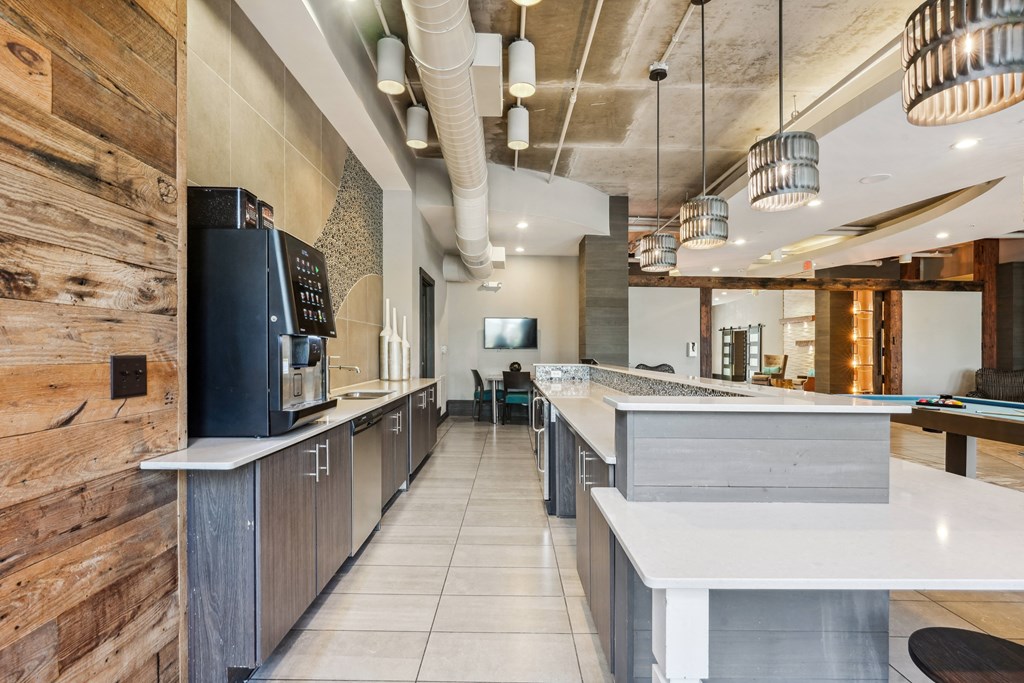 a restaurant with a long counter with a coffee machine and a refrigerator