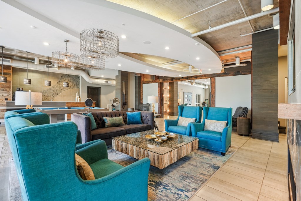 the lobby of a hotel with blue chairs and couches