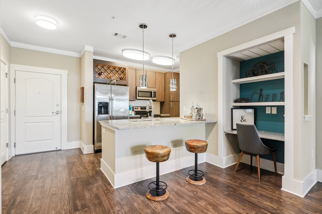 a kitchen with a large island and a bar with two stools