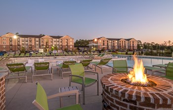 Dusk image of firepit and pool with buildings in the background - Photo Gallery 21