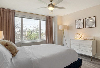 a bedroom with a bed and a ceiling fan