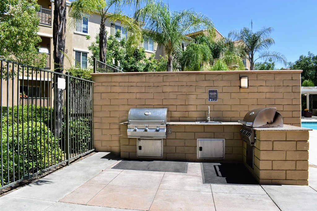 a barbecue grill in a brick wall next to a pool