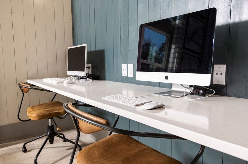 a desk with a computer monitor and a chair