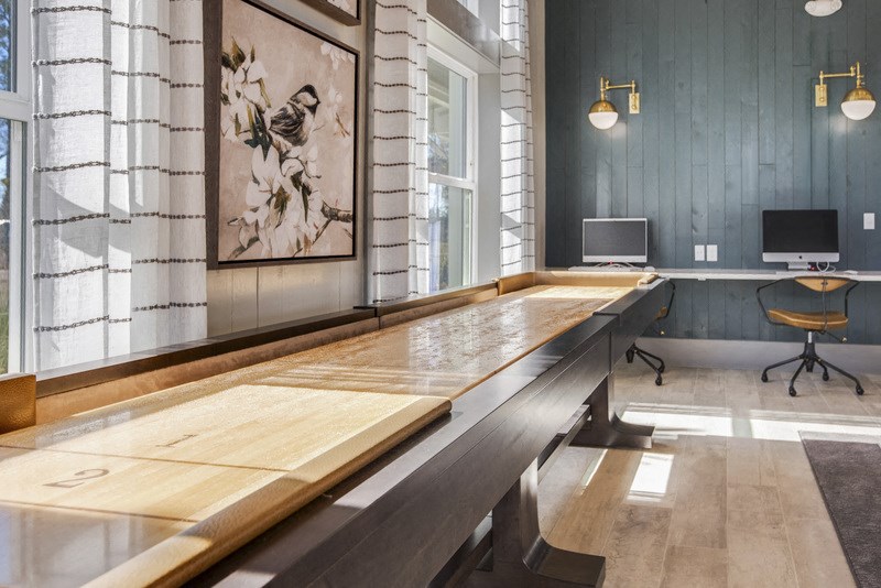 a large pool table in a room with a window and a computer