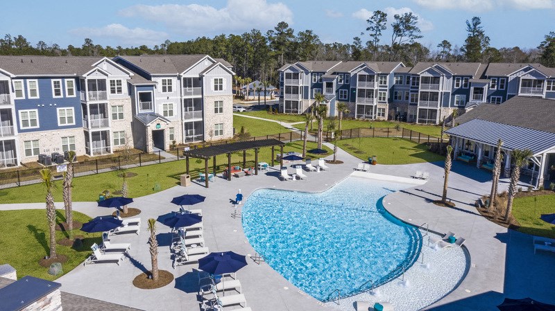 an aerial view of a swimming pool in front of an apartment building