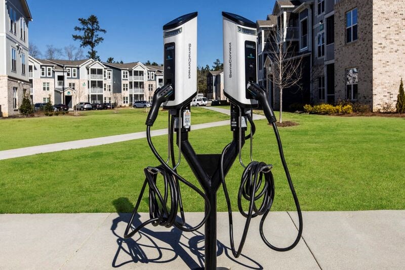 two charging stations on the sidewalk in front of an apartment building