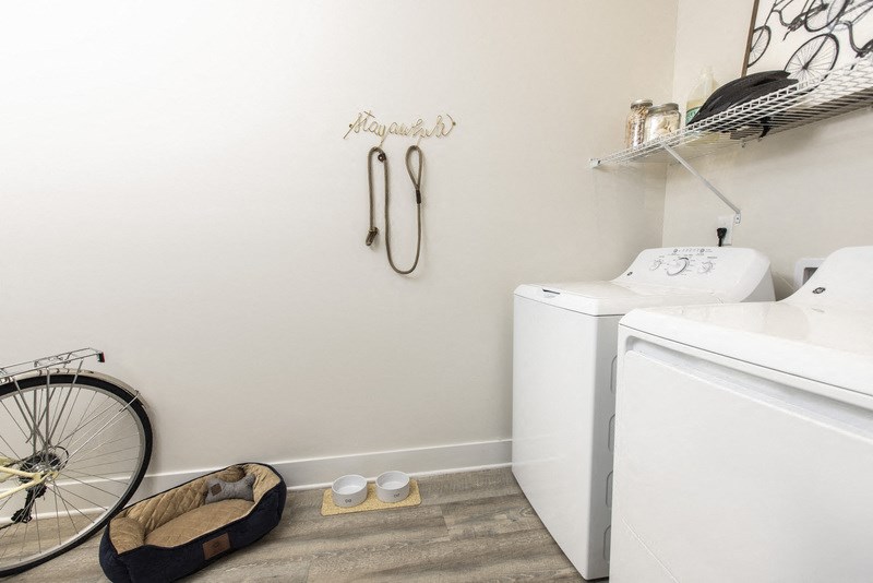 a washer and dryer in a laundry room with a bike in the corner