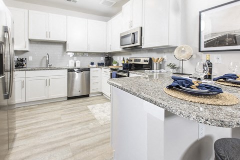 a kitchen with white cabinets and granite counter tops