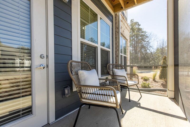 a front porch with two chairs and a door