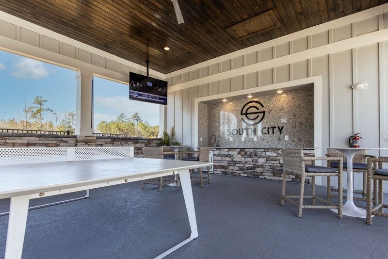 a ping pong table on the patio of a building with tables and chairs