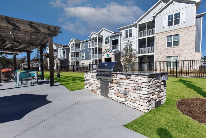 an outdoor patio with a barbecue grill in front of an apartment building