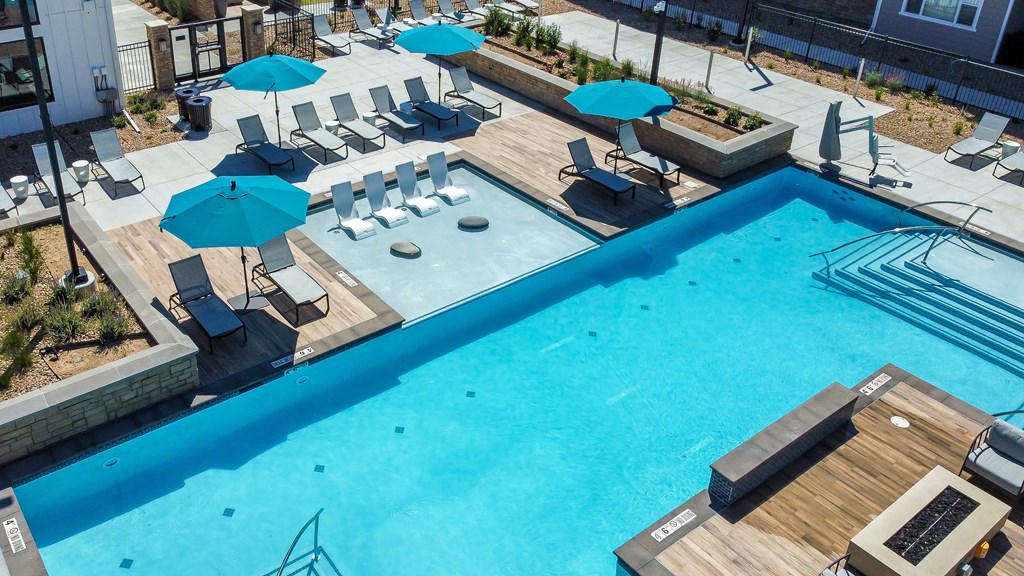 a swimming pool with chairs and umbrellas