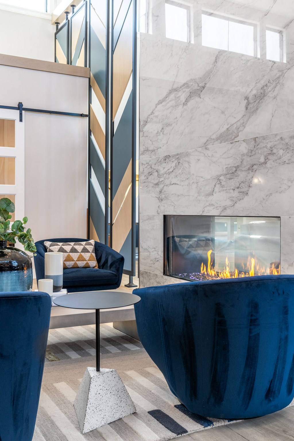 a living room with a fireplace and blue furniture