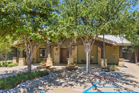 A house with a driveway and a tree in front.