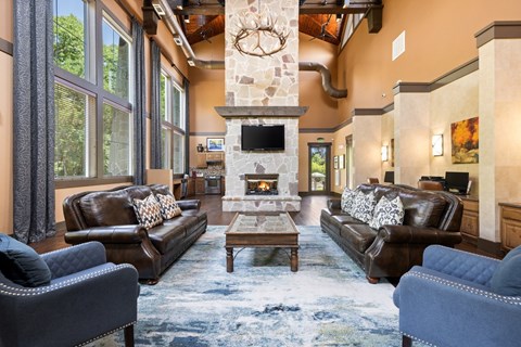 A living room with a fireplace and a stone mantle.