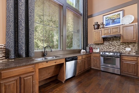 A kitchen with wooden cabinets and a stone backsplash.