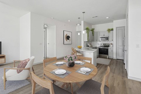 A modern dining room with a wooden table set for two.