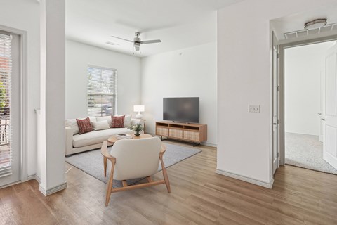 A living room with a white chair and a wooden floor.
