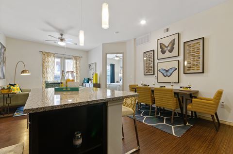 an open kitchen and dining area with a granite counter top and a dining room table