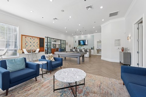A living room with blue couches and a rug.