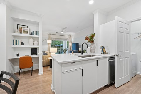 A kitchen with white cabinets and a wooden floor.