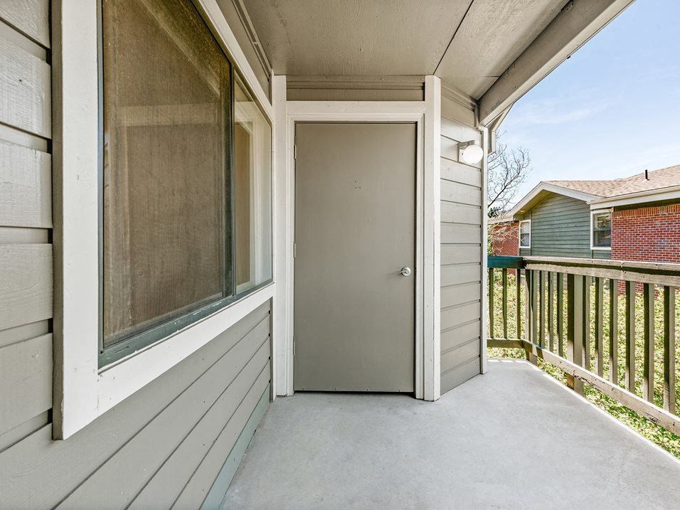 the front porch of a house with an open door