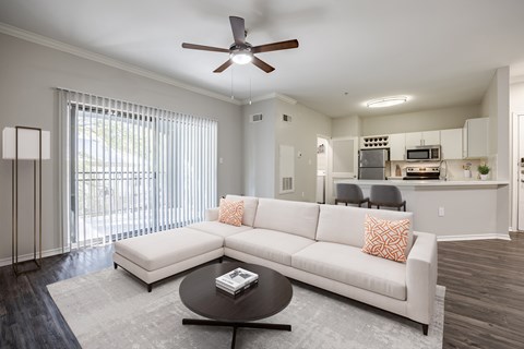 A living room with a white couch and a ceiling fan.