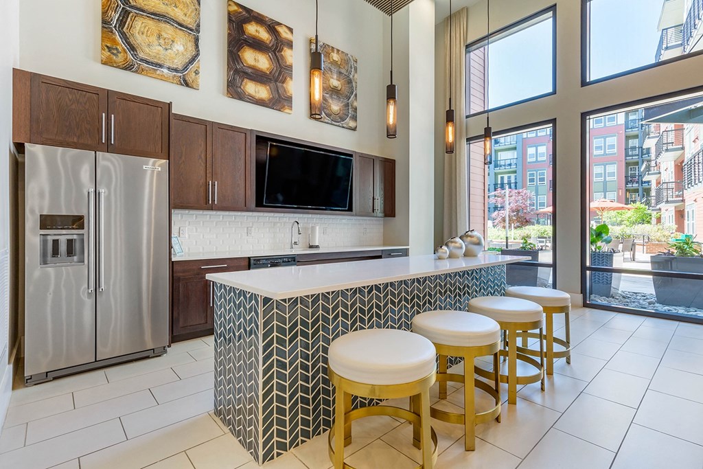 a kitchen with a bar with four stools