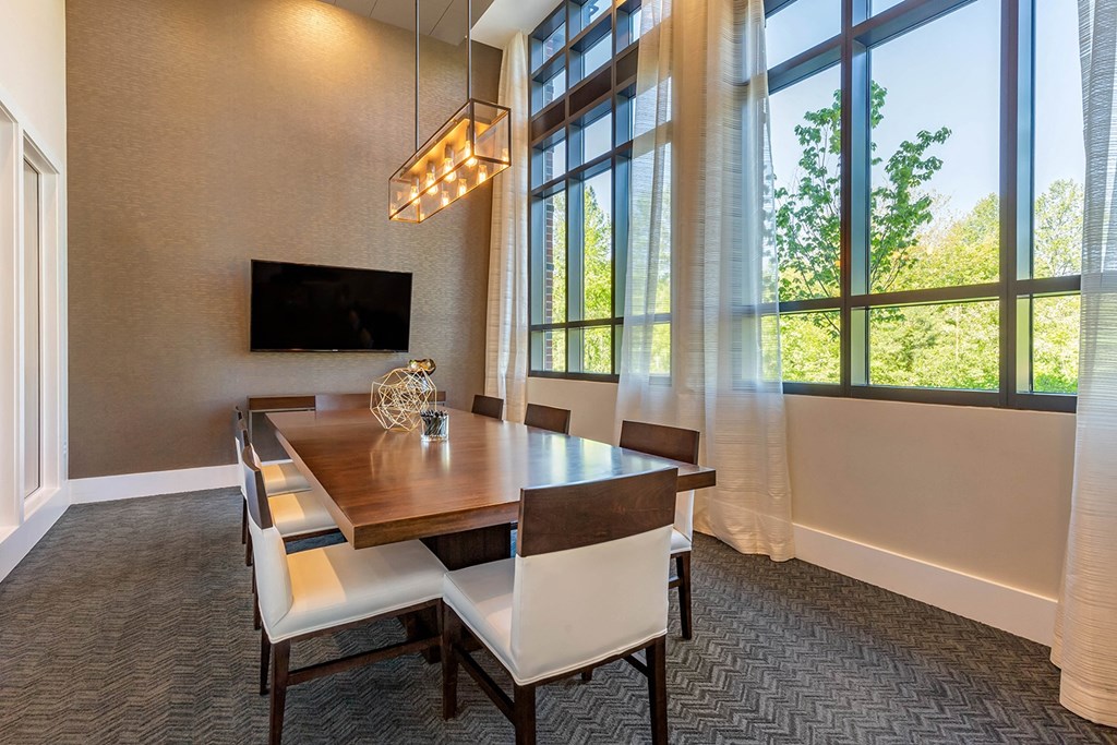 a dining room with a table and chairs and a large window