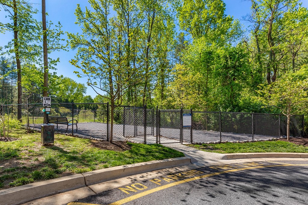 the entrance to a park with a fence and benches