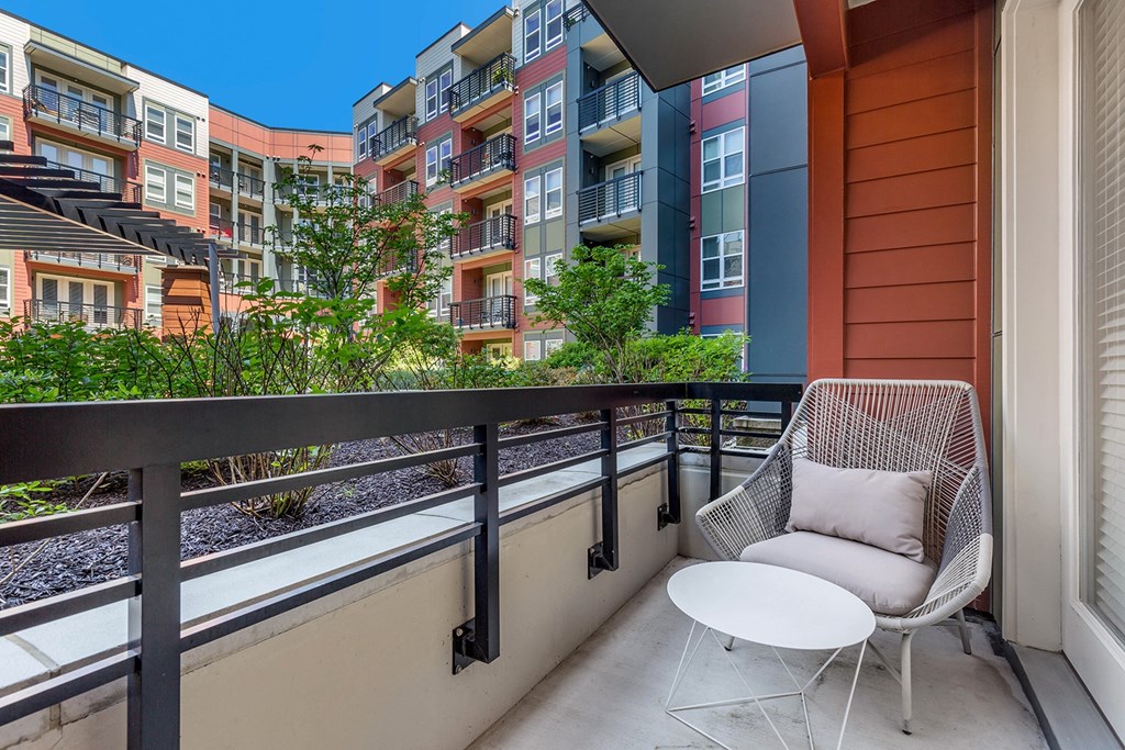 a patio with a chair and a table on a balcony