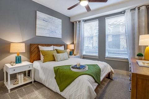 a bedroom with windows and a ceiling fan