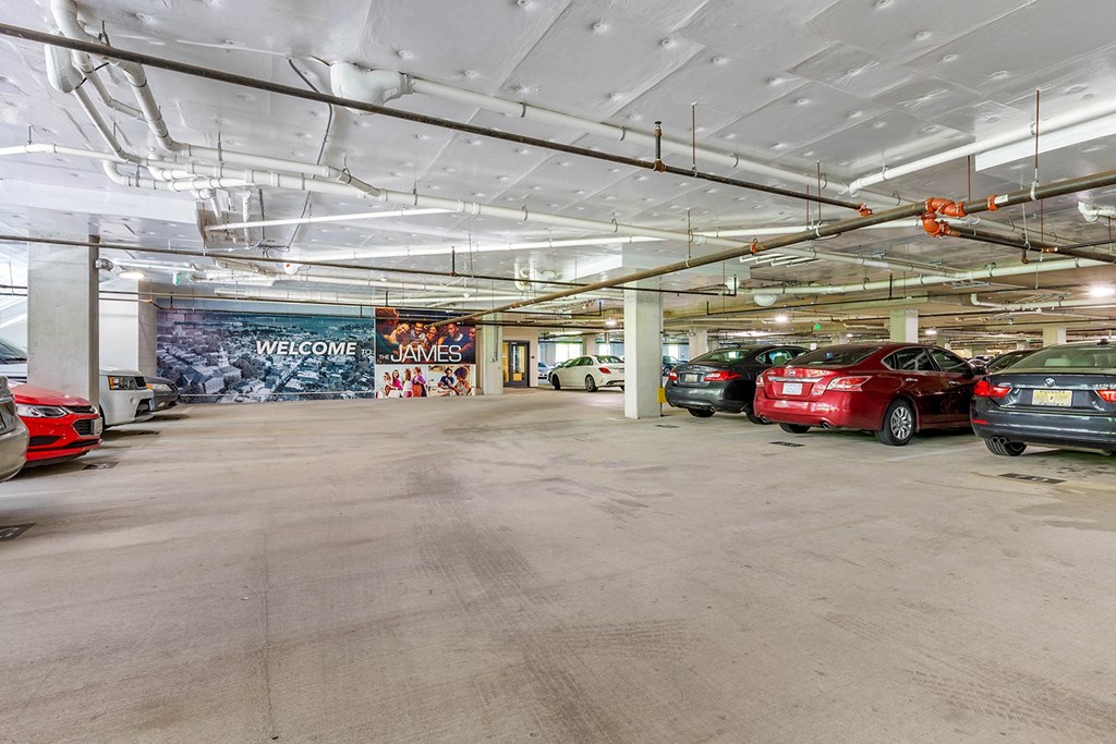 a parking garage with cars in it and a mural on the wall