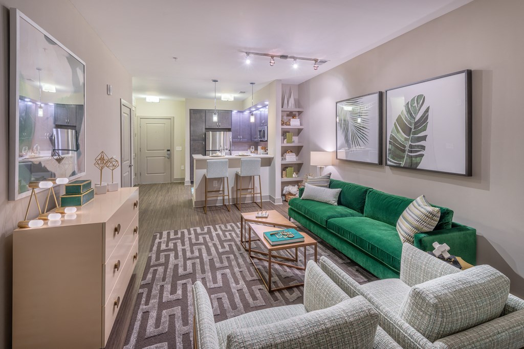 a living room and kitchen with a green couch