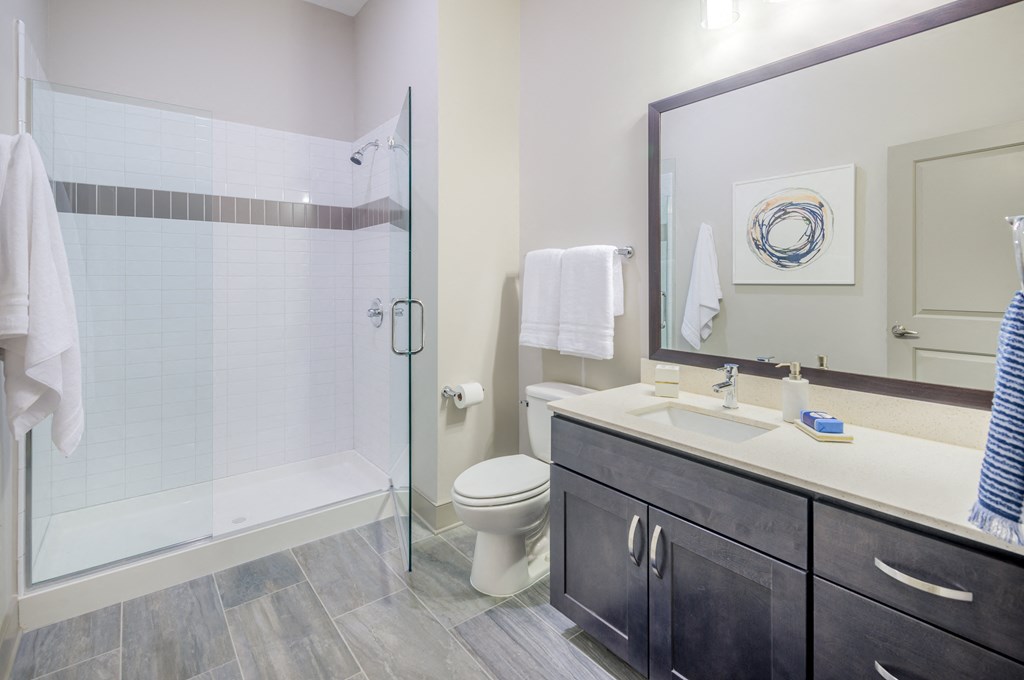a bathroom with a shower and a sink and a mirror