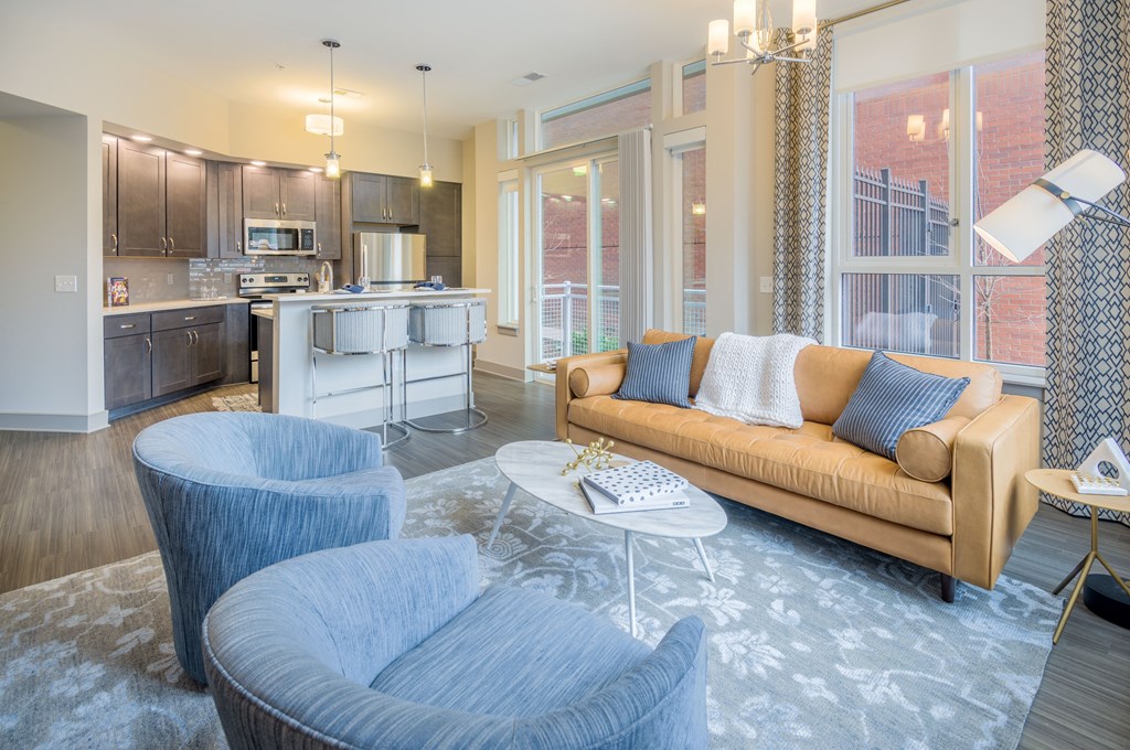 a living room and kitchen with blue chairs and a couch