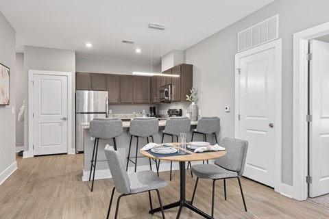 A kitchen with a table and chairs in the middle of the room.
