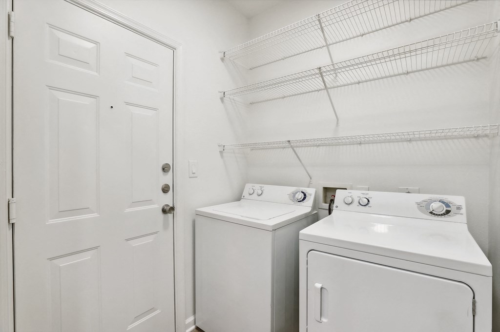 a white washer and dryer in a laundry room with a white door