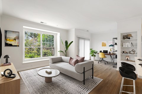 A living room with a white couch and a coffee table in front of a window.
