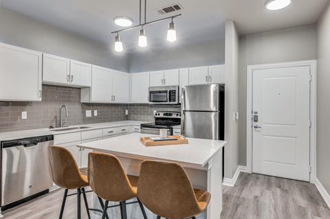 A kitchen with a white table and chairs.