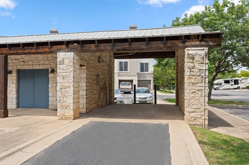 a stone building with a garage with a car parked in the driveway