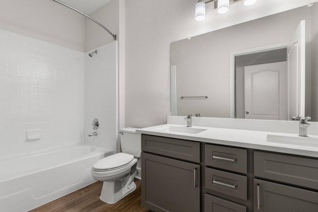a white bathroom with a white toilet and a sink and a bath tub