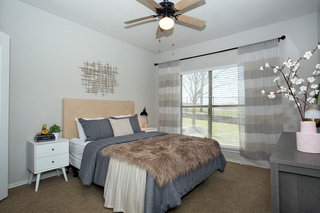 a bedroom with a bed and a ceiling fan