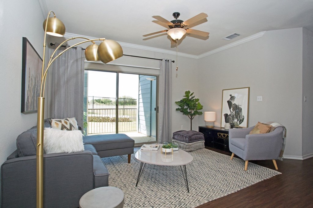 a living room with a ceiling fan and a sliding glass door